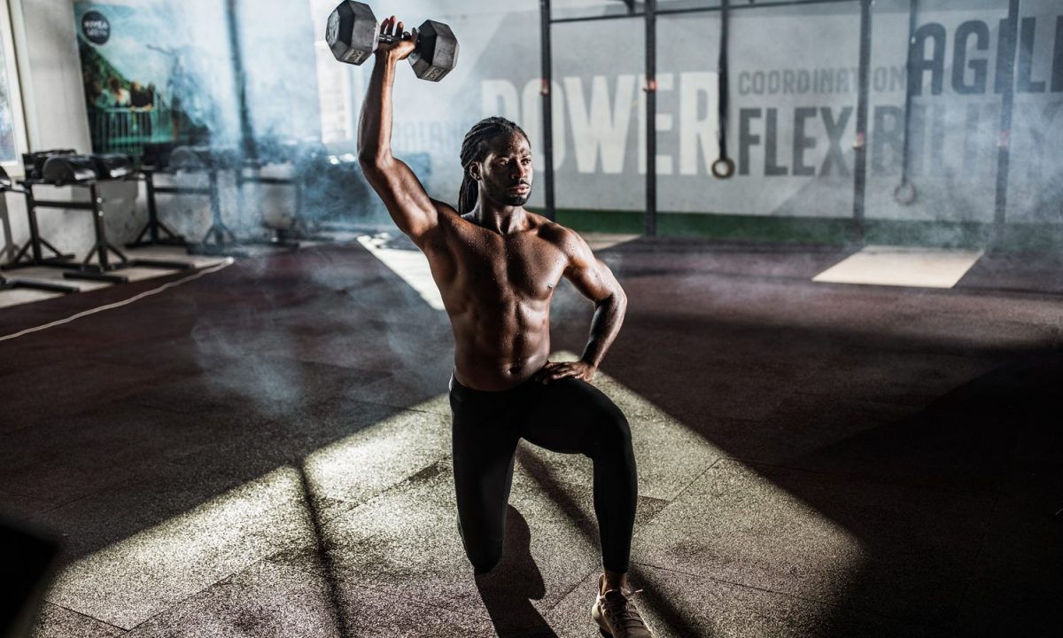 An athlete doing the single-arm reverse lunge and overhead press
