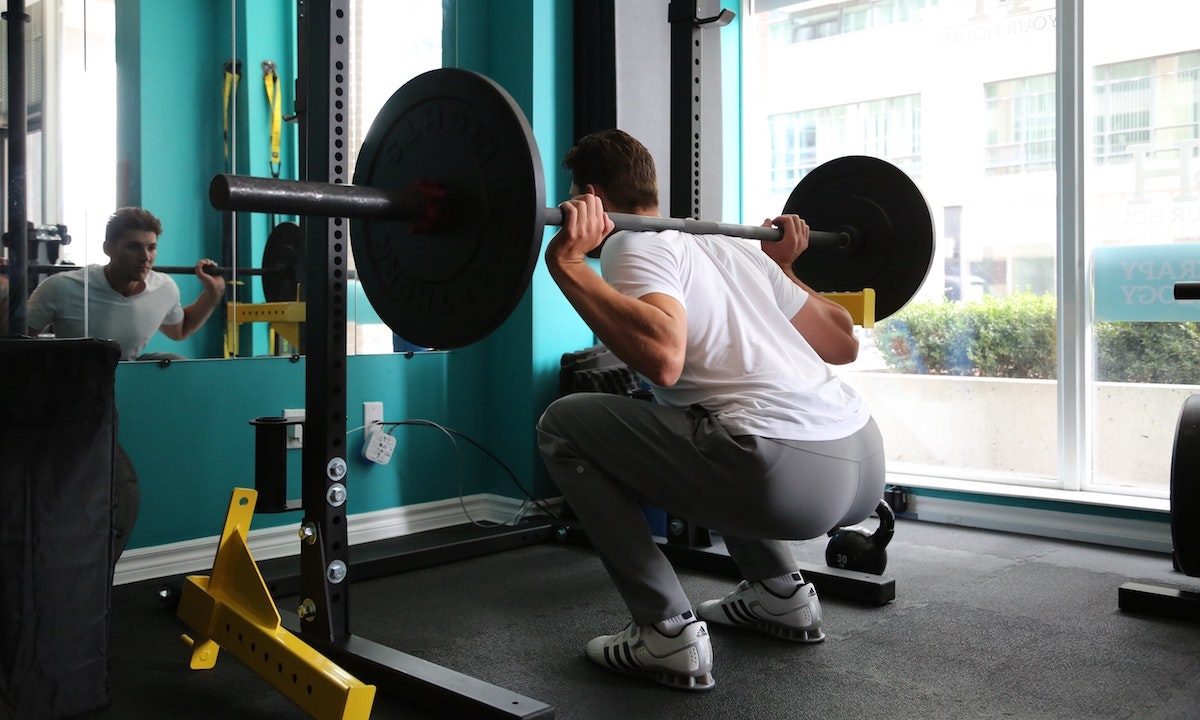 Man doing heavy back squat for glutes