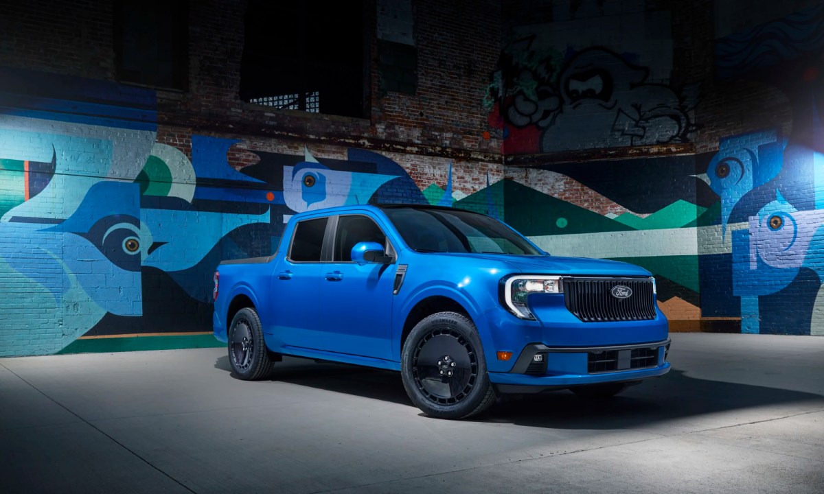 2025 Ford Maverick Lobo street performance truck right front three-quarter view parked in font of gray brick wall covered with street art.