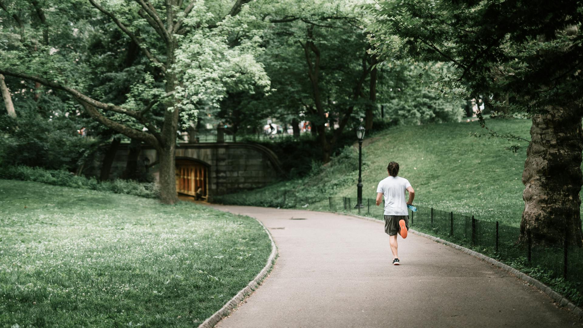 Man running jogging outdoors outside in nature on a path