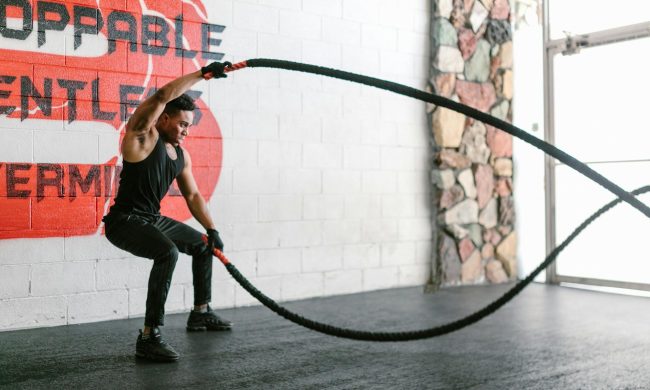 man doing HIIT ropes gym
